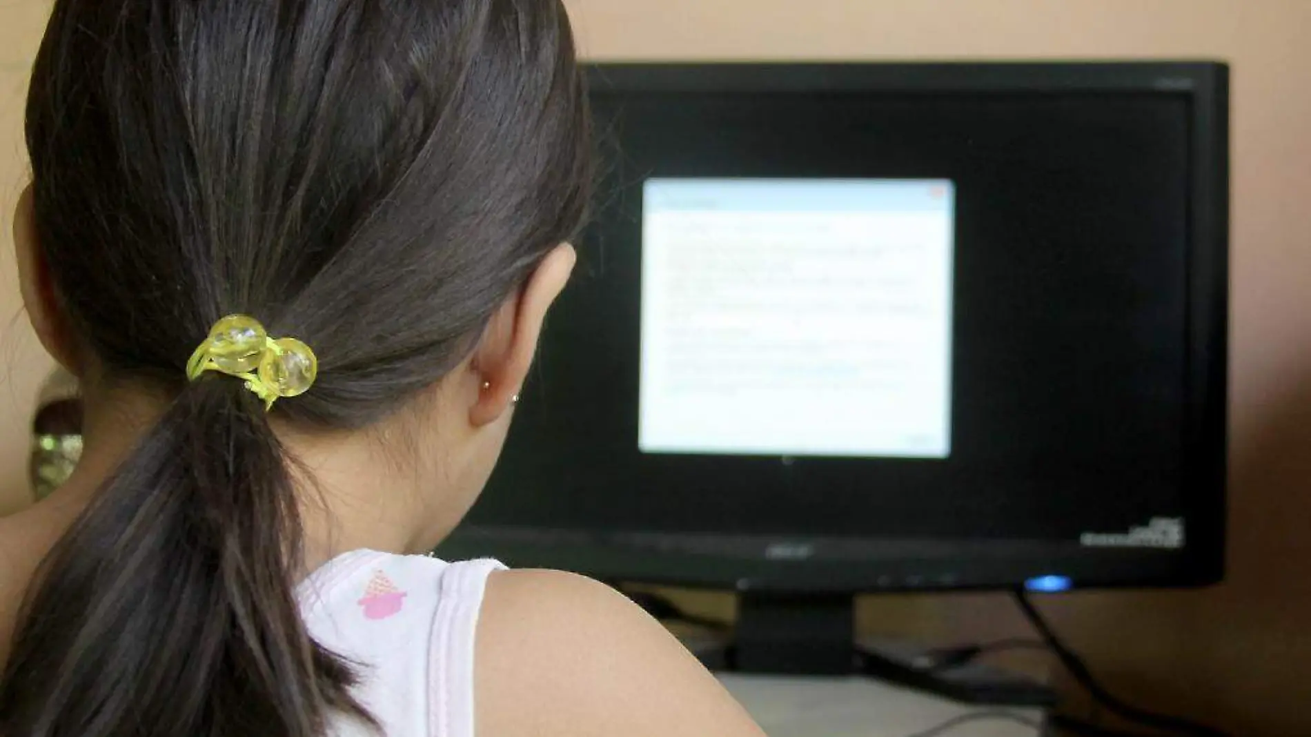 Niña frente a una computadora